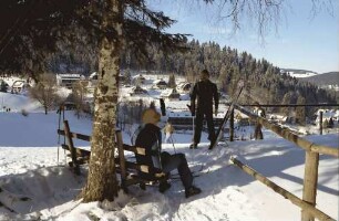 Hinterzarten: Blick auf Häuser am Hang vom Kesslerhang; Vordergrund Mädchen auf Bank