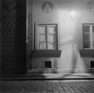 Teilansicht einer mit Kratzputz verzierten Hausfassade bei Nacht
