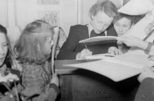 Ausstellung der Deutsch - Polnischen Gesellschaft: "Polnische Kinder zeichnen und malen" in der Öffentlichen Wissenschaftlichen Bibliothek : Polnische Künstlerin beim Signieren von Büchern