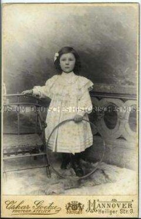 Porträt eines dreijährigen Mädchens im weißen Kleid mit Reifen