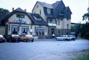 Vorderansicht des Bahnhofgebäudes mit Gaststätte und Parkplatz
