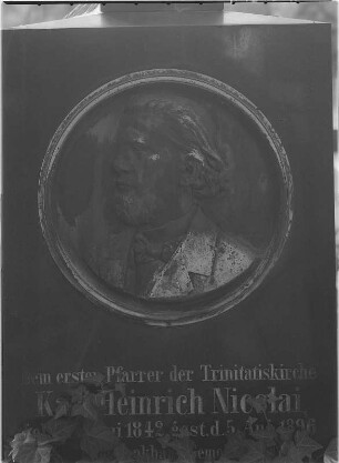 Grabmal für Pfarrer Karl Heinrich Nicolai (1842-1896). Detail: Porträtmedaillon und Inschrift. Gabbro, Zinkguß? Dresden-Johannstadt, Trinitatisfriedhof
