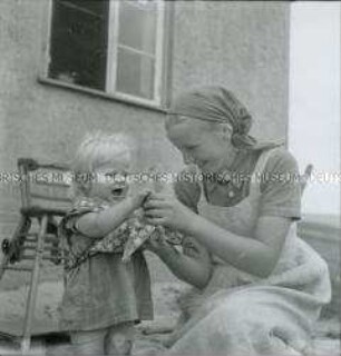 Arbeitsmaid des Reichsarbeitsdienstes bei der Kinderbetreuung