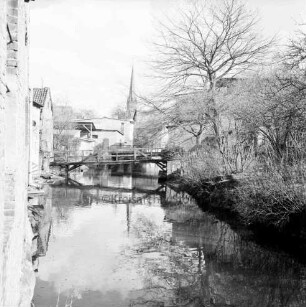 Trave: Stadtarm hinter Hindenburgstraße: Blick von der Brücke "Hamburger Torbrücke" an der Hagenstraße Richtung Peter-Paul-Kirche: links und hinten Gebäude: rechts Garten: hinten Mitte Fußgängerbrücke