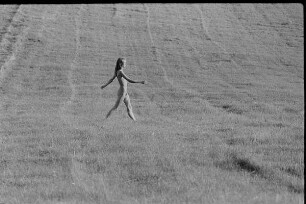 Čičmany. Akt-Pleinair 1980. Abgeerntetes Feld mit einer darüber laufenden jungen Frau