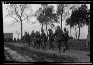 "Vermutlich an der Straße Fins - Nurlu (beide Dep. Somme, Frankreich)": "marschierende Infanterie mit Stahlhelmen" auf einer unbefestigten Landstraße (Rückansicht)