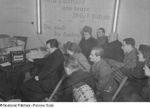 Zuhörer vor dem Radio sitzend