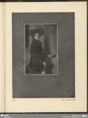 [Junge Frau in schwarzer Robe an einer Tür]