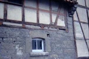 Teil eines Wirtschaftsgebäudes, Fenster; am Ortgang vorkragende Steine