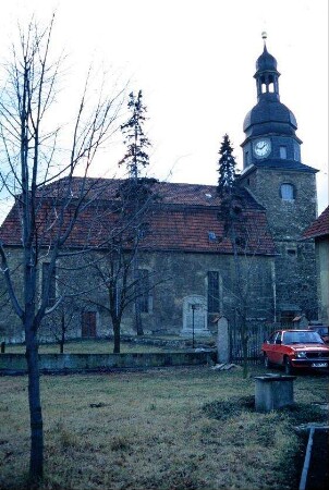 Kirche mit Turm, Laterne und Uhr; vor der Kirche Kriegerdenkmal