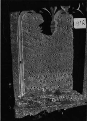 Grabstein 41 (Index: 99798246) Material: Sandstein, rot Zustand: stark verwittert Maße HxBxT: 123x56x11 cm Beschreibung: Stele, Spitzbogenabschluß, Sockel Symbolik: Maßwerk: Grabstein 41A