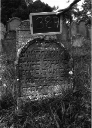 Grabstein 387 (Index: 100102847) Material: Sandstein Zustand: stark verwittert, teilweiser Textverlust Maße HxBxT: 67x48x9 cm Beschreibung: Stele, eingezogener Rundbogenabschluss, Schriftfeld eingetieft: Grabstein 387
