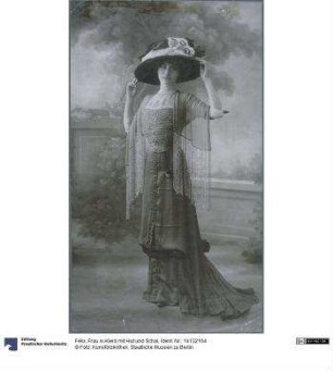 Frau in Kleid mit Hut und Schal