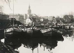 Berlin-Spandau. Frachtkähne im Hafen von Spandau. Im Hintergrund der Turm der im 14. Jh. errichteten gotischen Kirche St. Nikolai