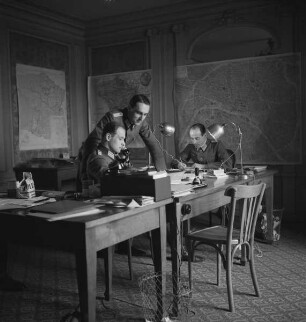 Die Mitarbeiter des Militärischen Kunstschutzes beim Oberkommando des Heeres Carl Heinz Pfitzner (links), Wend Graf von Kalnein (stehend) und Bernhard von Tieschowitz (rechts) in ihrem Arbeitszimmer im Hotel Majestic in Paris (Aufnahme im Rahmen der Fotokampagne im besetzten Frankreich)