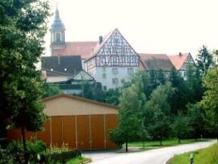 Ansicht von Norden mit Kirche (Barocker Neubau 1796) in erhöht liegendem Kirchhof mit randständiger Gebäudegruppe in Übersicht
