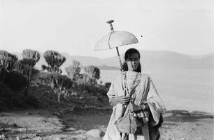 Frau mit Sonnenschirm : Frau mit Sonnenschirm und Bastbehälter am Ufer des Hayksees