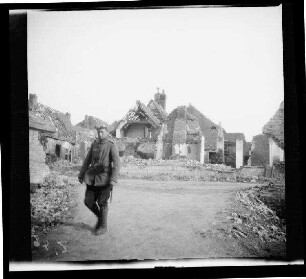 Messines (=Mesen, Belgien): Gebäuderuinen umgeben von Trümmern, im Vordergrund ein Soldat ("Dorfbild aus Messines")