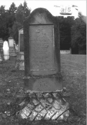 Grabstein 35 (Index: 99609671) Material: Sandstein Zustand: stark verwittert, weitgehender Textverlust Maße HxBxT: 153x48x19 cm Beschreibung: Stele, eingezogener Konvexbogenabschluß, Schriftfeld rechteckig eingetieft, getreppter Sockel, unten Rusticaimitat Symbolik: segnende Hände: Grabstein 35