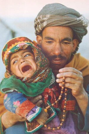 Afghanischer Vater mit weinendem Kind in einem Flüchtlingslager 1986 in Pakistan