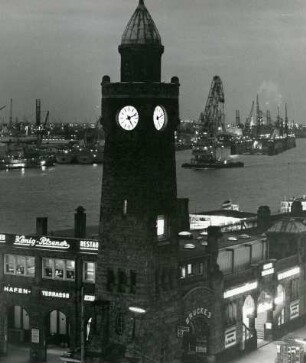 Hamburg-St. Pauli. Die Landungsbrücken in der Dämmerung. Im Vordergrund der Pegelturm