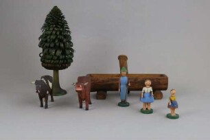 Hölzernes Spielzeug mit zwei Kühen, zwei Mädchen, einem Hirten, einem Brunnen und einem Baum