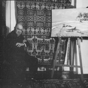 Der Maler Prof. Ernst Vollbehr (1876-1960) in seiner Wohnung, vor einer Staffellei sitzend