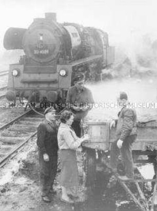 Eisenbahner dämpfen mit ihrer Lokomotive zum Einsilieren bestimmte Kartoffeln der LPG Altlüdersdorf (Kr. Gransee)
