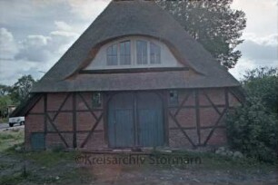 Ohe: Hoibeken 2: Fachwerkkate mit Reetdach: Giebelseite mit Scheunentor