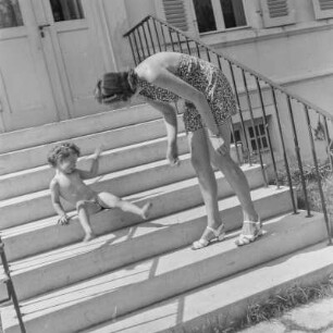 Kleines Mädchen auf einer Treppe sitzend schreckt von ihrer Mutter zurück