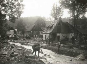 Unwetterkatastrophe im Osterzgebirge am 8./9. Juli 1927. Zerstörte Häusergruppe in Schönwald (heute Petrovice-Krásny Les). Ansicht mit beginnenden Aufräumarbeiten