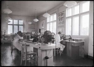 Fotografie: Zwei Frauen an Arbeitsplätzen im Metallographie-Labor