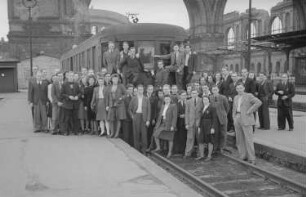 Aufnahmen einer Gruppe junger Leute vor einer Straßenbahn