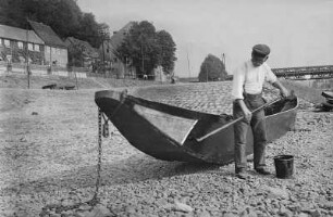 Meißen. Ein Fischer teert seinen Kahn am Ufer der Elbe