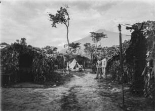 Dorf am Mount Meru : Dorf am Fuße des Mount Meru. Rechts in Uniform stehen Hauptmann Kurt Johannes (rechts außen) und ein weiterer Mann