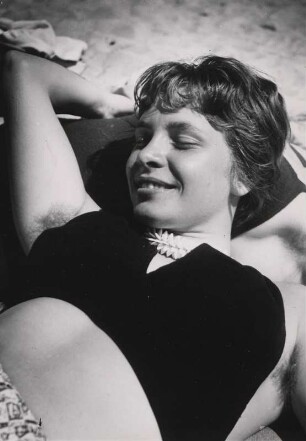 Frau liegt am Strand