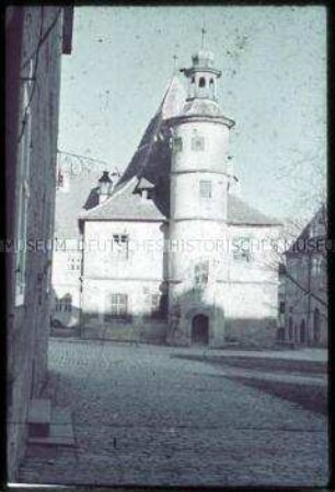 Dorf aus strohgedeckten Holzhäusern an einer Sandstraße