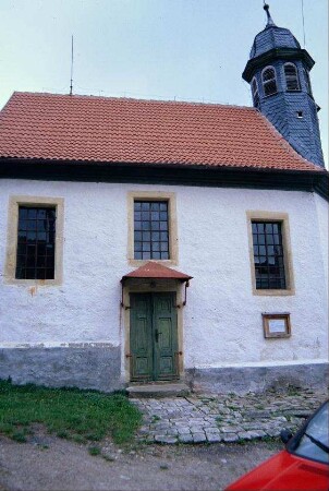 Eingangsbereich der Kirche mit zweiflügeliger Tür und Türüberdachung