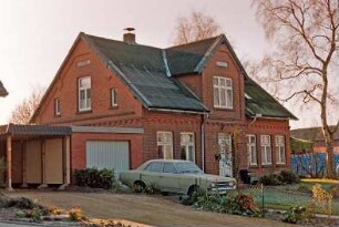 Lindenstraße 1: traufständiges Backsteinhaus: Straßenfront mit mittigem Eingangsrisalit: Giebelseite, oben Schriftfeld mit Jahreszahl 1900: links Garagenanbau