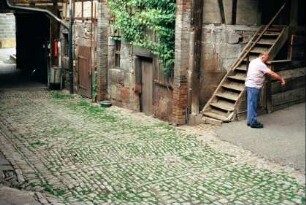 Blick in den Innenhof eines Gehöftes; kleinteiliges Kalksteinpflaster; Ernst Große