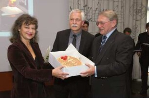 SLUB, Ausstellung "Die Kunst zu essen und zu genießen" : Feierliche Übergabe der Schenkung durch Walter Putz und Ausstellungseröffnung am 21. September 2007 im Vortragssaal. Doris Ander-Donath und Dr. Thomas Bürger überreichen dem ehemaligen Generaldirektor der SLUB, Prof. Jürgen Hering, eine Torte zu dessen 70. Geburtstag