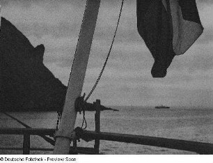 Nordkap. Fahrt entlang der Steilküste mit markanter Felsnase. Blick zu einem vorbeifahrenden Schiff