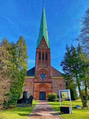 Siek: Friedenskirche: Westfassade mit Turm, davor Weg mit Informationskasten