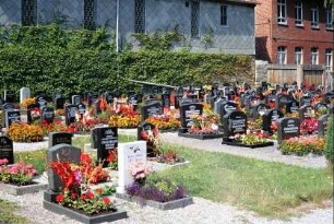 Grabstätten auf dem Friedhof; Wirtschaftsgebäude gleichzeitig Friedhofsbegrenzung