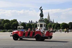 Wien - Oldtimerbus : Ein offener Oldtimerbus fährt mit Touristen über den Wiener Heldenplatz, vorbei am Reiterdenkmal für Erzherzog Karl. 2008