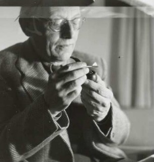 Der Komponist Carl Orff beim Anzünden einer Pfeife in seiner Wohnung