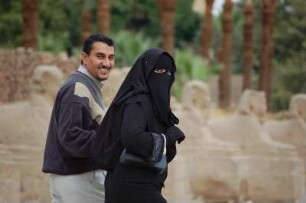Luxor - verschleierte Frau : Elegant gekleidetes ägyptisches Paar, Frau traditionell verschleiert, im Luxor-Tempel. Aufgenommen in Luxor am 13. Januar 2006