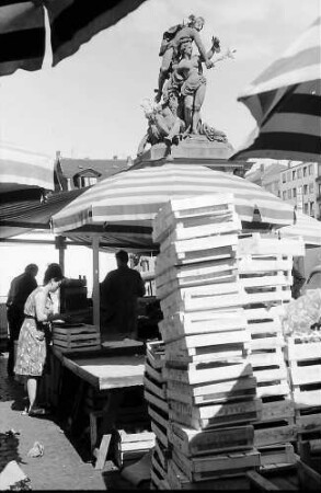 Mannheim: Brunnenfigur hinter Marktkisten