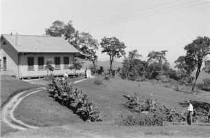 Im Camp der Standard Oil und Co : Blick auf ein Haus mit Garten und Personen