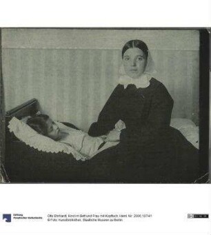 Kind im Bett und Frau mit Kopftuch